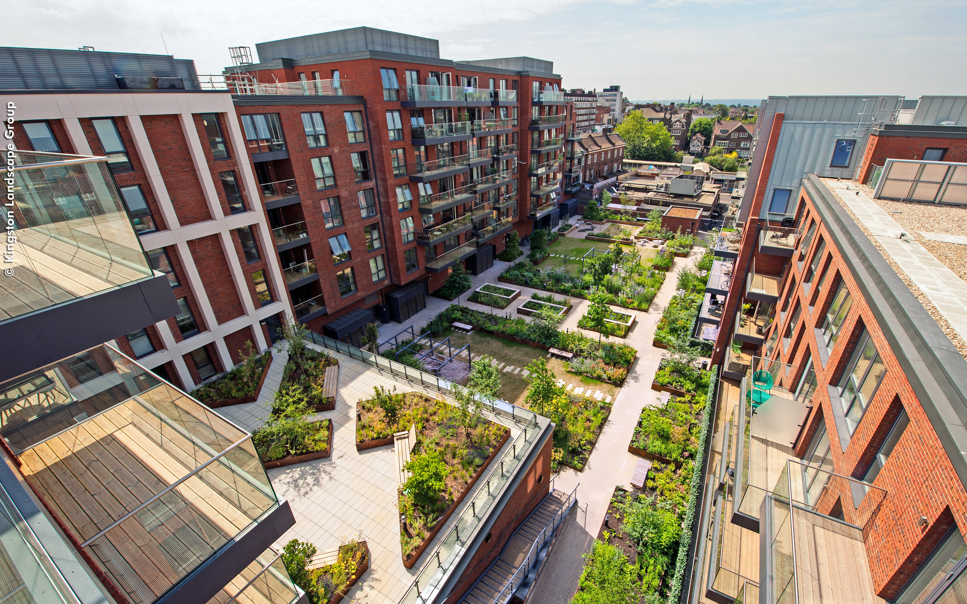 Most of the apartments are facing into the inner courtyard serving as a green oasis to the residents. Bird's eye view onto the green courtyard surrounded by multi-storey buildings